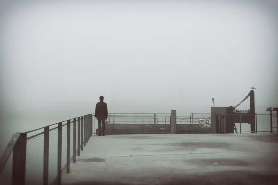 Un homme seul face à la mer, dans la brume grise du matin. 10° Lauréat du concours photo WinSPOT by Data Concept