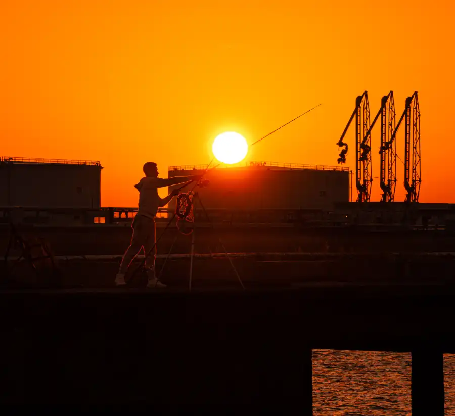 Un pêcheur au lever du jour devant des silo sur le port du havre 7° Lauréat du concours photo WinSPOT by Data Concept
